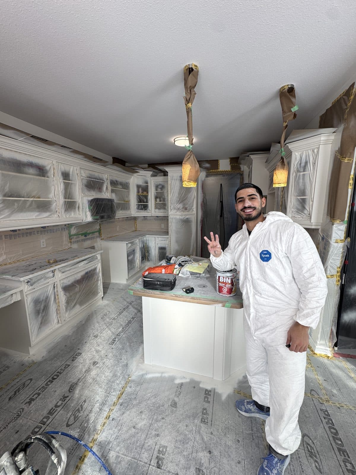 Spray suit white cabinet primer Owner wearing a white spray suit during a cabinet primer project