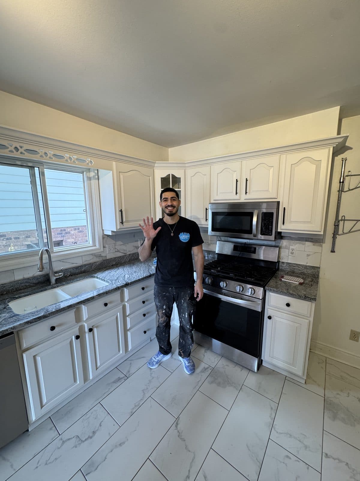 White cabinets with gray countertops Owner in a white painted cabinet kitchen with gray countertops after refinishing