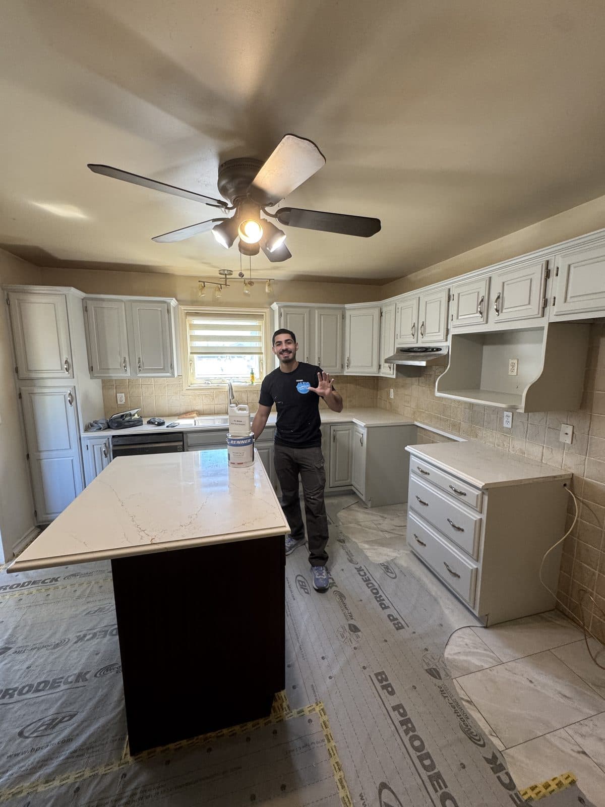 White cabinet refinish floor protection White cabinet refinishing project with floor protection and owner holding paint