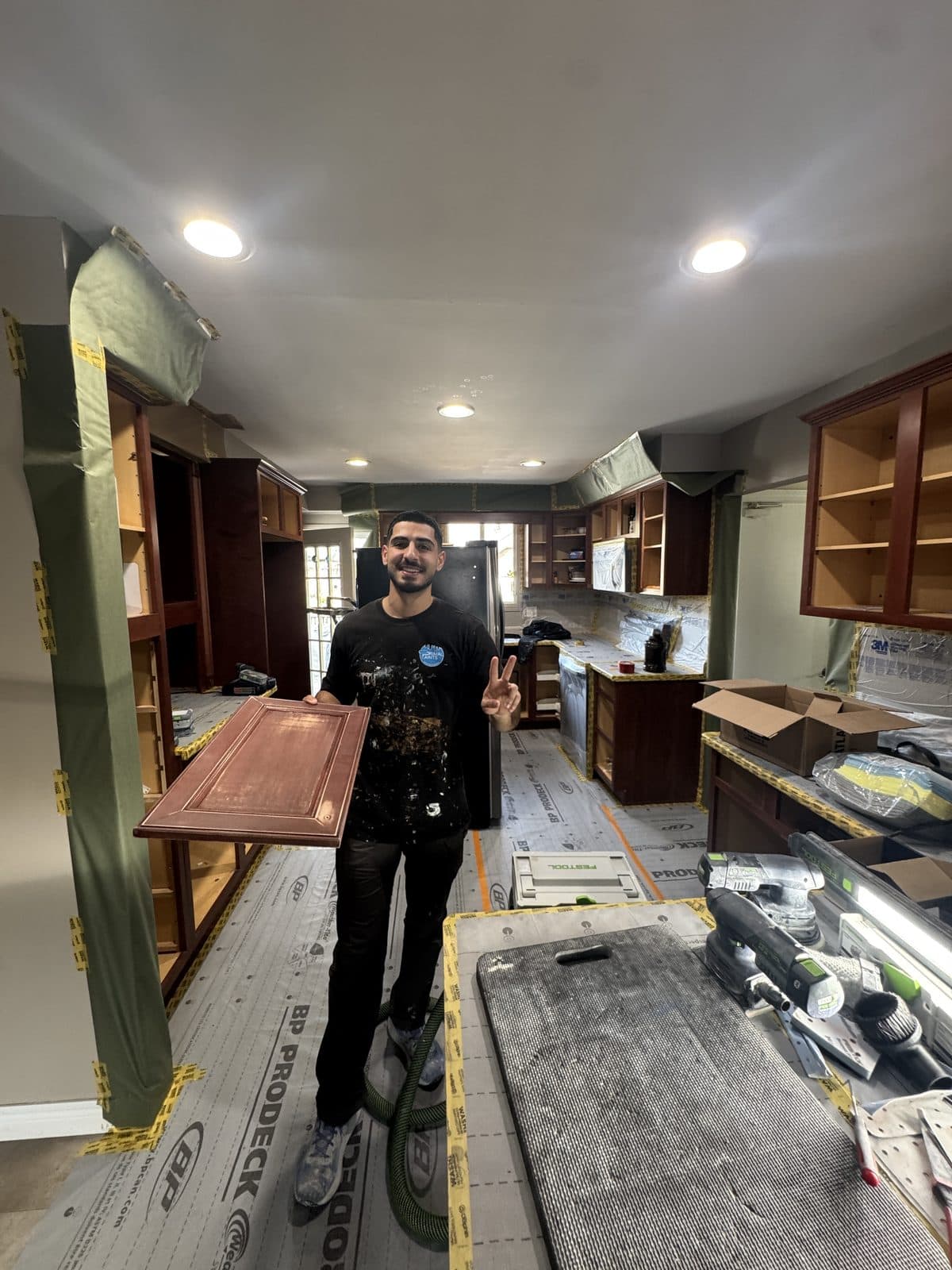 Wood cabinet door refinish prep Owner holding a wood cabinet door during refinishing preparation